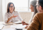 Female financial advisor two older clients in an office.