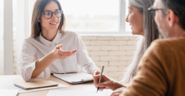 Female financial advisor two older clients in an office.