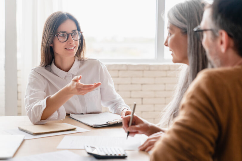 Female financial advisor two older clients in an office.