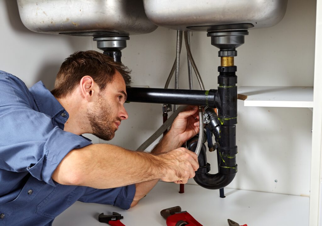 Plumber fixing a pipe with specialist tools