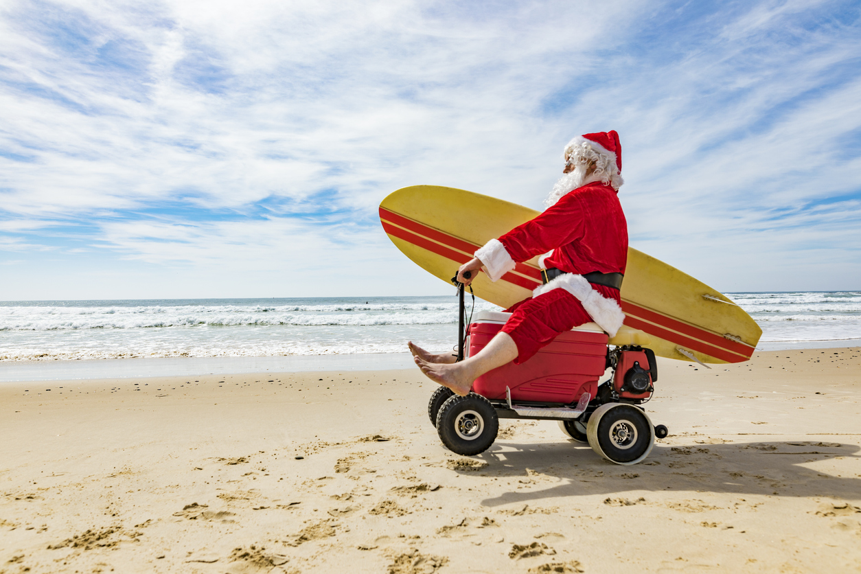 Santa Claus Doing a Wheelie on a Motorised Esky Cooler on the Beach