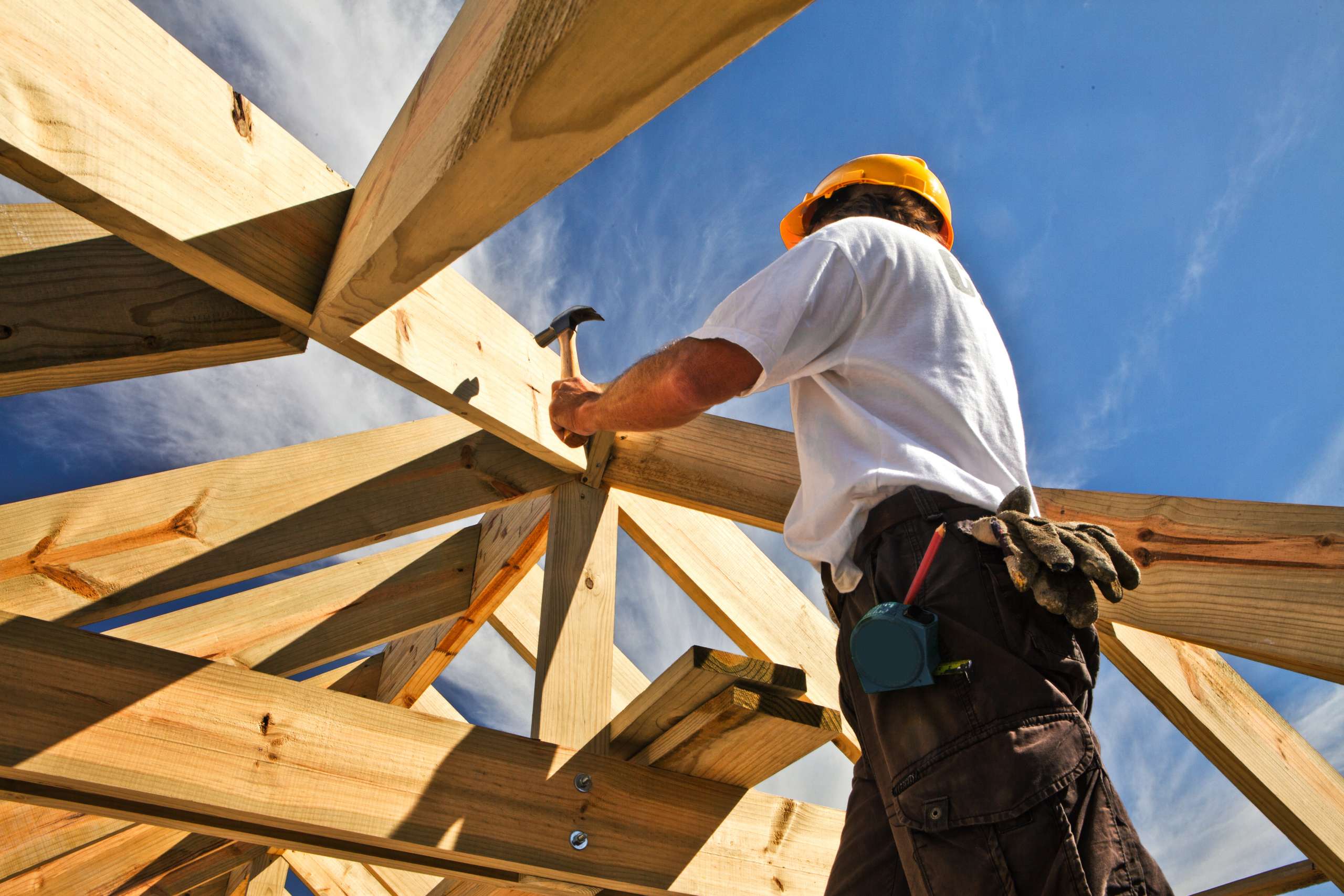 Carpenter working on roof structure at construction site