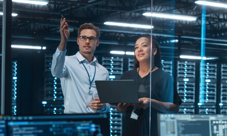 Two IT professionals working in a server room