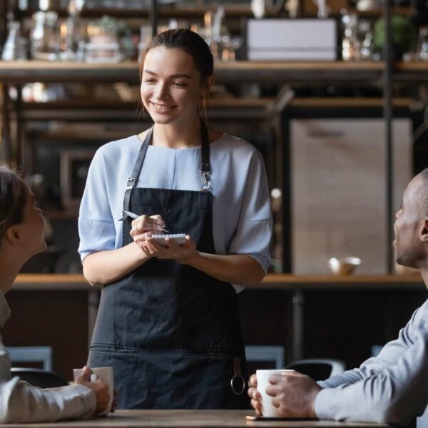 A waitress with notebook taking order from clients.