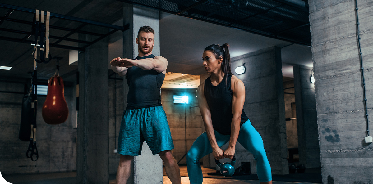 Fitness professionals performing exercises in a gym